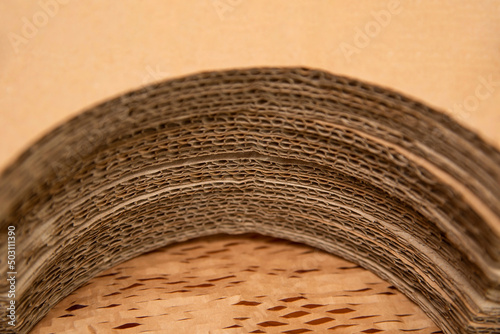 Corrugated cardboard lies in a semicircle. Sheets of corrugated cardboard are prepared for special packaging of round items. Plsce for text photo