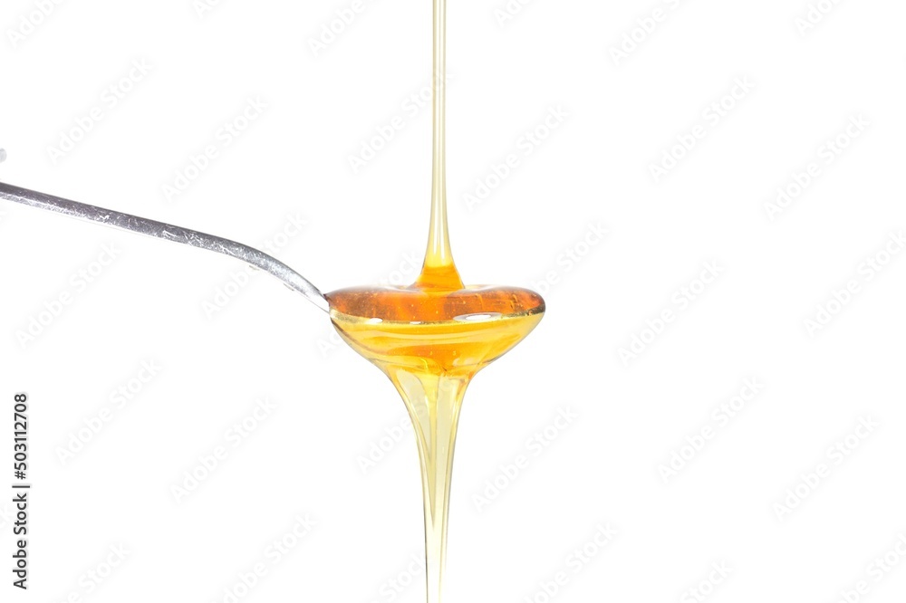Image of honey on a spoon on a white background Image of honey on a spoon on a white background