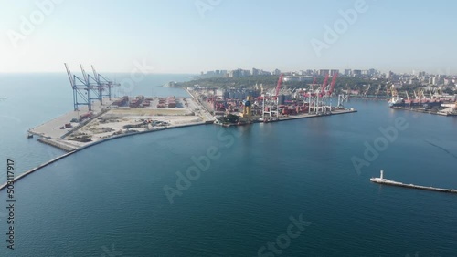 Sea port cargo cranes container terminal aerial shot. Storage warehouse cargo dock at Odessa Ukraine Black Sea. Giant cranes and lighthouse