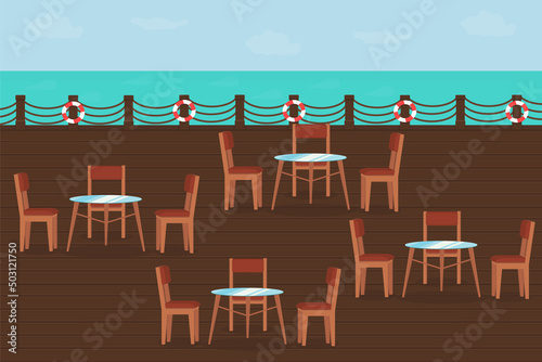 restaurant terrace with wooden deck chairs and tables near the sea in summer