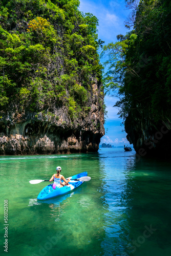Woman on kayak in calm tropical lagoon on Koh Hong island