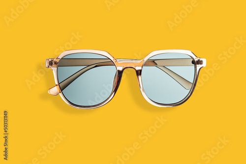 Gold sunglasses on yellow background, concept of summer, vacation