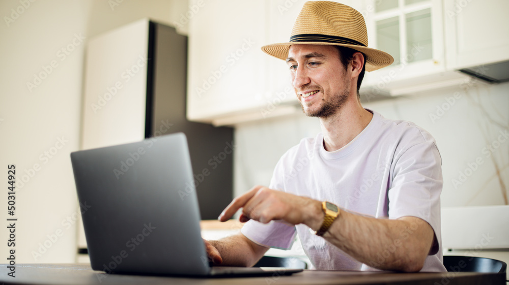 Man at laptop at home workplace chooses the point of destination for trip or working at home, studding on online courses with internet. Man at laptop at home workplace chooses the point of destination for trip or working at home, studding on online courses with internet.