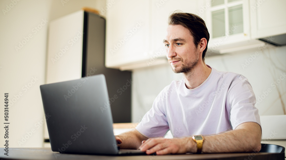 Man at laptop at home workplace chooses the point of destination for trip or working at home, studding on online courses with internet. Man at laptop at home workplace chooses the point of destination for trip or working at home, studding on online courses with internet.