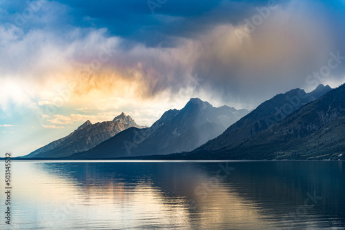 Reflective lake and rocky mountains in Grand Teton National park under the gloomy sky in Wyoming