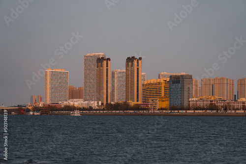 Scenic view of the Harbin City on the shore of the Songhua river at sunset photo