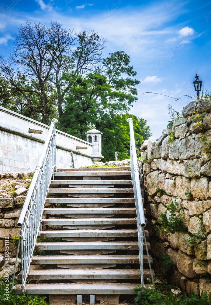 White iron stairs. Iron stairs of Pidhirtsi castle on a background of blue sky