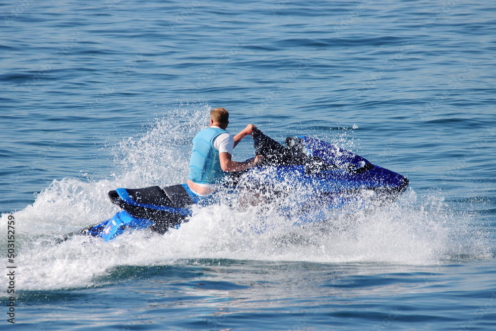 Young man enjoying water sport ride on jet ski