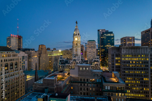 Aerial Drone View of Philadelphia Skyline at Sunset with Glowing City Lights with Town Hall in Foreground 