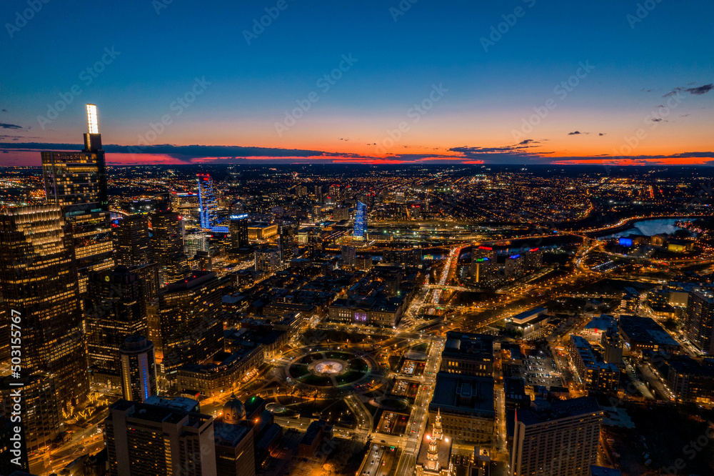 Obraz premium Aerial Drone View of Philadelphia Skyline at Sunset with Glowing City Lights