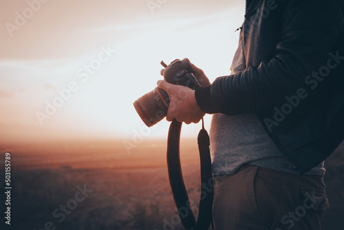 photographer photographs the sunset on the mountains photo
