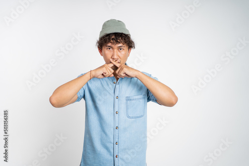 portrait of a man with hands covering mouth standing over isolated background. stop talking concept