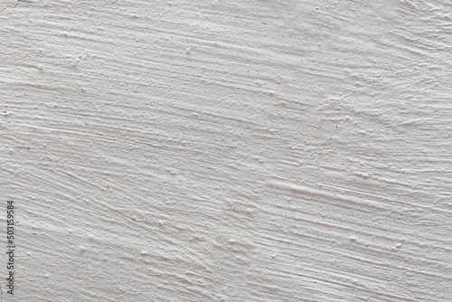 The background is in the form of gray rough plaster on the wall, whitewashed with chalk. Plaster tecture close-up. photo