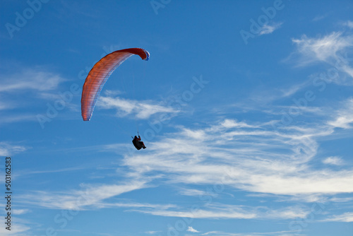 Beautiful view of a person paragliding over mountains in Bezau, Austria