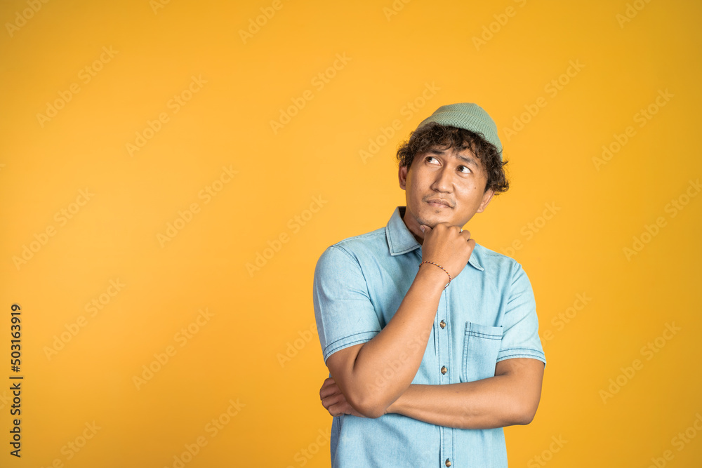 portrait of unsure asian young man thinking on isolated background