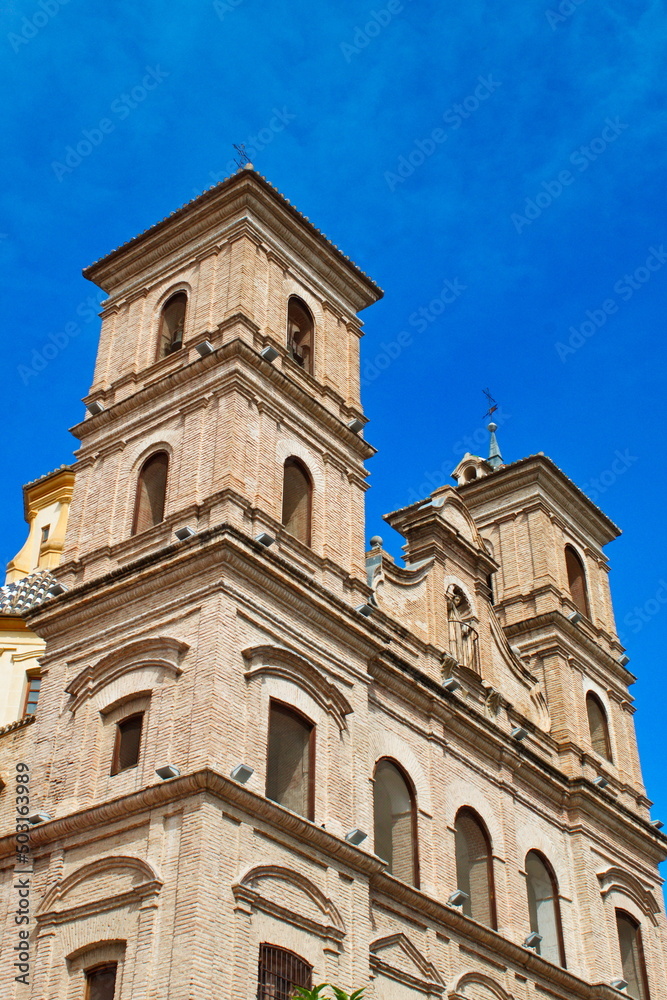Back facade of the Church of Santo Domingo in Murcia made of brick, with towers and arches
