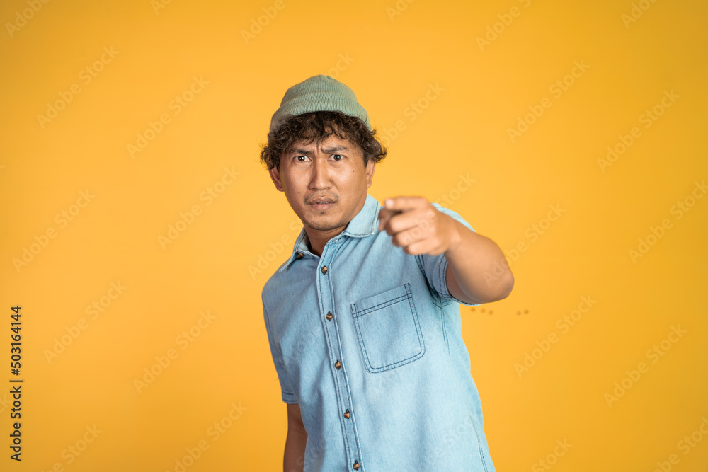 scared young man with finger pointing forward and blaming gesture on isolated background