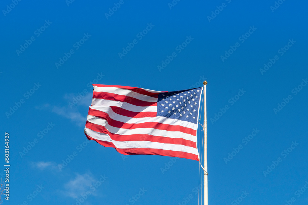 American flag - star and stripes floating over a blue sky