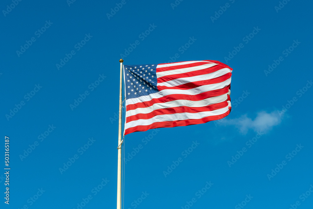 Obraz premium American flag in front of blue sky