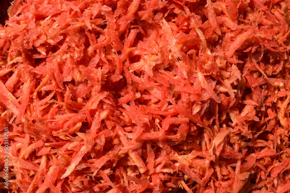 Fototapeta premium Fresh grated carrot vegetable preparation to make carrot recipes like gajar ka halwa. Grated carrot background