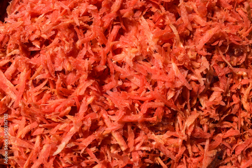 Fresh grated carrot vegetable preparation to make carrot recipes like gajar ka halwa. Grated carrot background photo