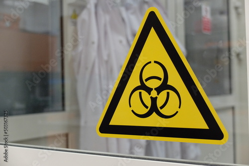 Biological hazard sticker on the doors to cell culture laboratory. Biohazard is a biological substance that poses a threat to the health of living organisms, primarily humans. photo