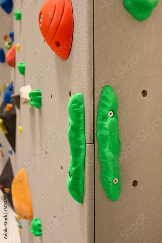 Close-up to green climbing holds on indoor bouldering wall