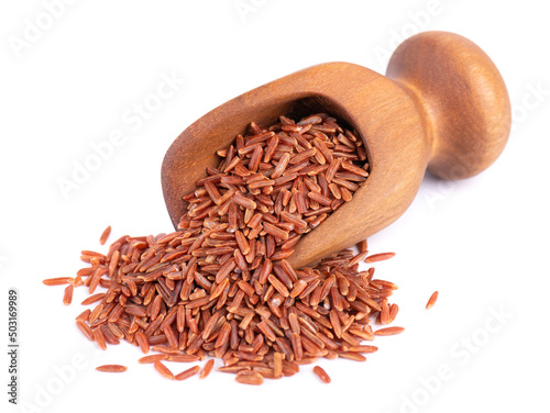 Red rice isolated in wooden scoop, on white background. Whole grain raw brown rice.