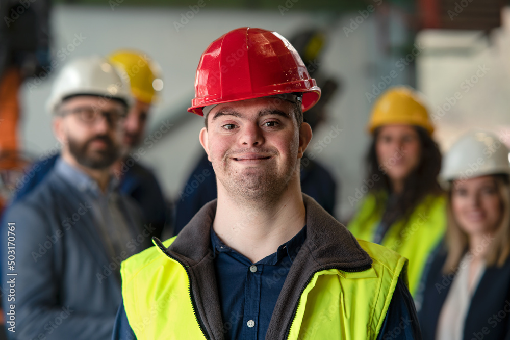 Young man with Down syndrome working in industrial factory, social integration concept. Young man with Down syndrome working in industrial factory, social integration concept.