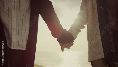 Young couple holding hands on sunset sky nature background. Love calm concept.