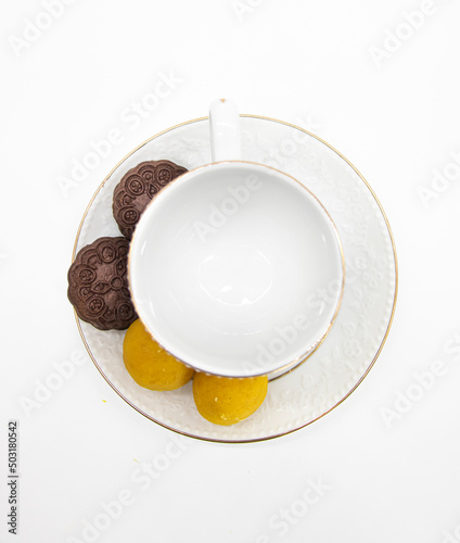 White tea cup for drink with biscuit over on white background. top view