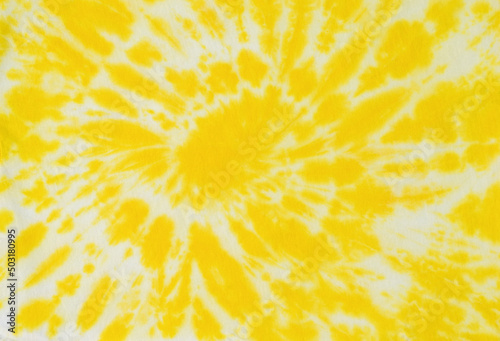 Beautiful white and yellow tie dye pattern on the fabric. Flat lay.