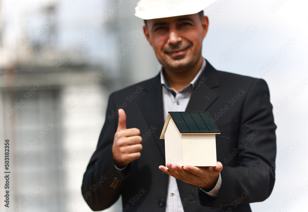 Project manager hold model of solar house on hand ,Renewable and Green energy concept ,Hand holding an energy efficient model house with solar panels, ecology and sustainability concept Project manager hold model of solar house on hand ,Renewable and Green energy concept ,Hand holding an energy efficient model house with solar panels, ecology and sustainability concept