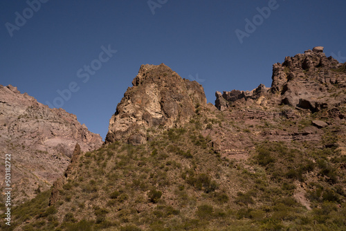 View of the arid desert and rocky mountains under a blue sky. 