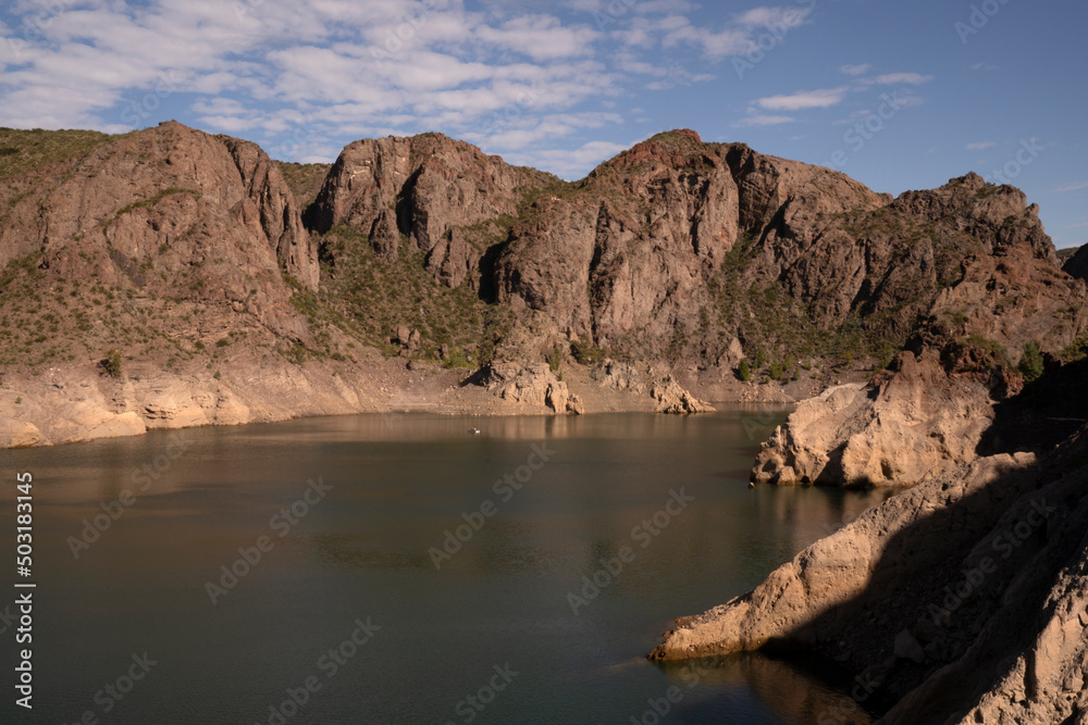 View of the lake, rock and sandstone hills in the desert.