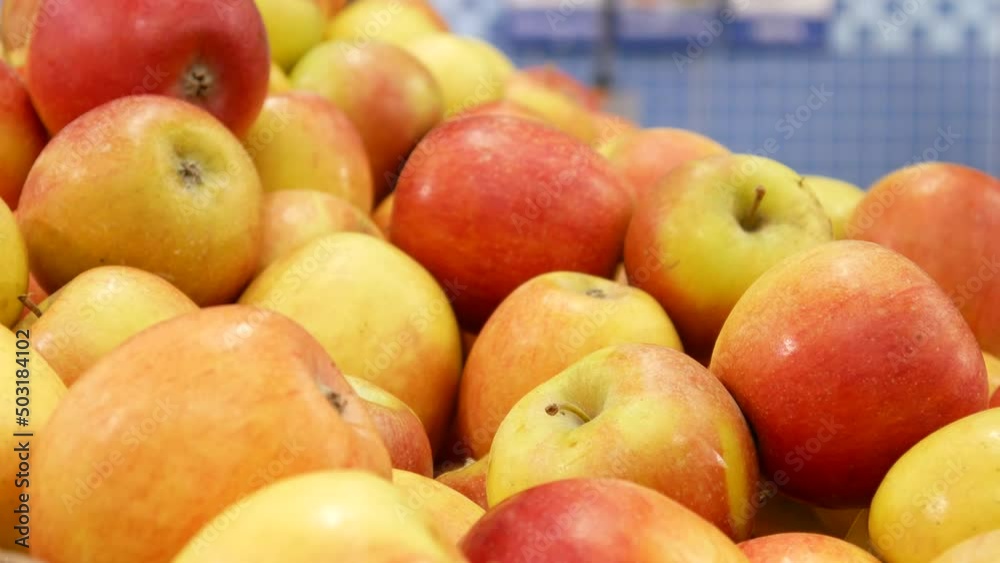 Close-up of a bunch of ripe apples in the market and a male hand takes one Close-up of a bunch of ripe apples in the market and a male hand takes one