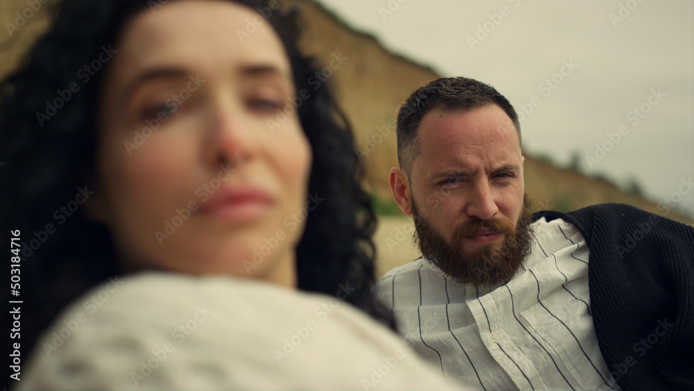 Multiethnic couple looking camera on sea beach. Two lovers enjoy laying outside. Multiethnic couple looking camera on sea beach. Two lovers enjoy laying outside.