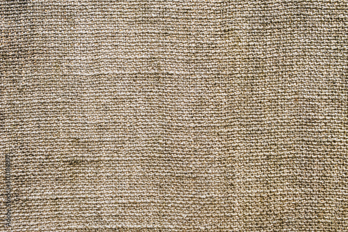 Background, texture of a crumbly fabric woven in spots of burlap close-up. Photography, abstraction.