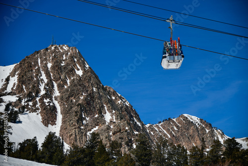 Gondola lift going up at the Snowbasin Ski Resort in Utah. Beautiful landscape of rocky mountains around. photo