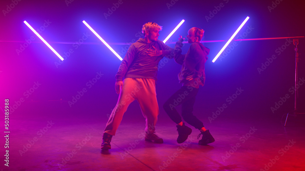 Couple performers making hiphop show in club. Two modern dancing street style.
