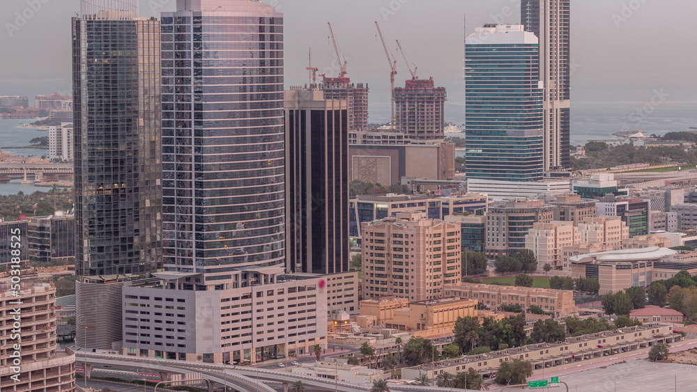 Office buildings in Dubai Internet City and Media City district aerial night to day timelapse