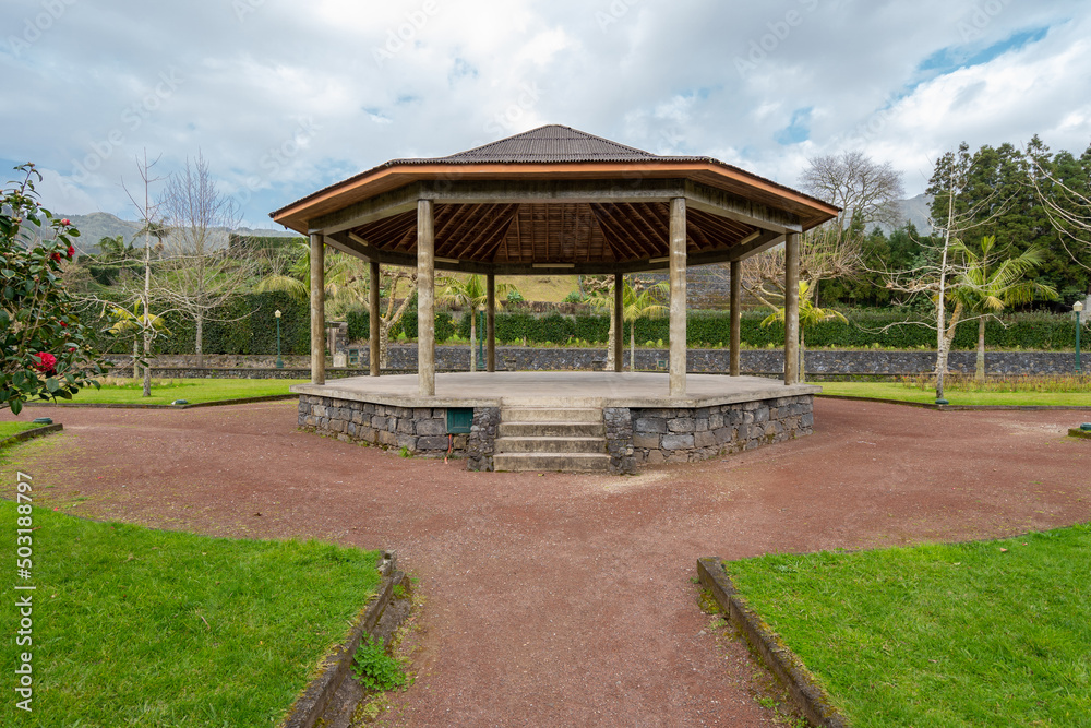 Wooden gazebo with concrete floor under slate roof in park Wooden gazebo with concrete floor under slate roof in park