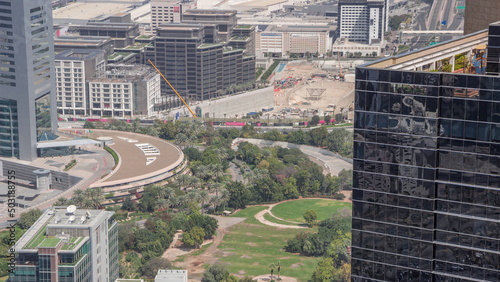 Park in financial district with large construction site with excatation including excavators and cranes timelapse