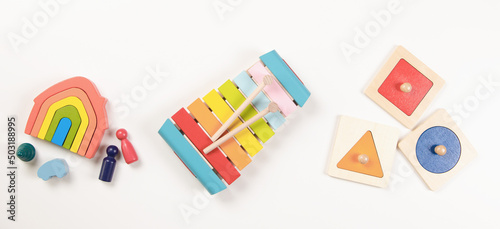 Baby kids toys. Top view to colorful educational wooden toys arranged on white background. Early education for kids. Learning music for children. Educational Montessori toys