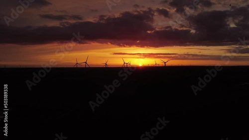 Drone video of the silhouette of a windpark at sunset