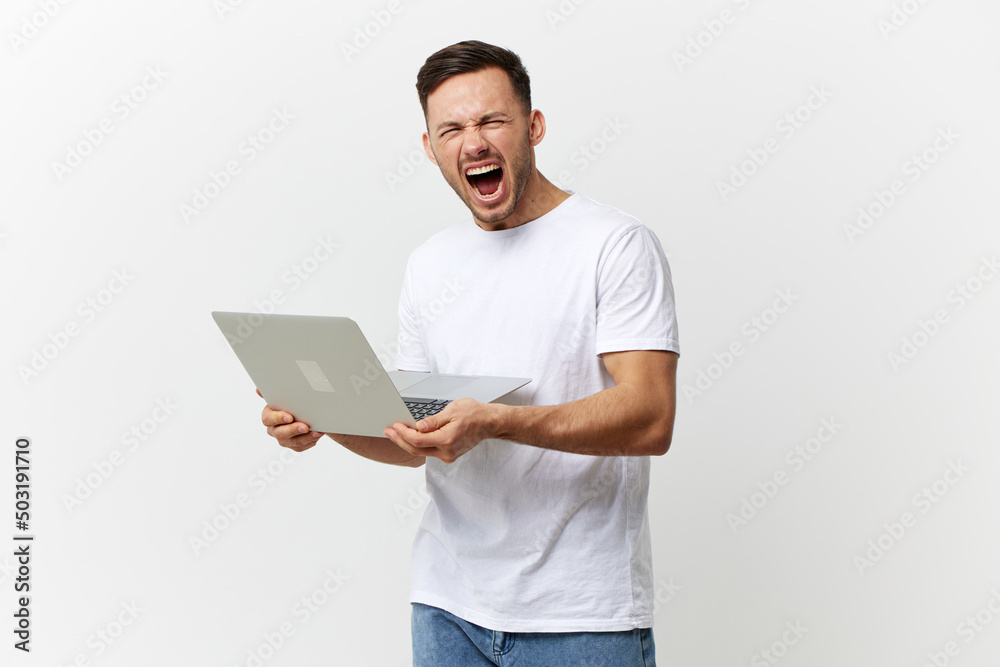 Aggressive angry crazy tanned handsome man in basic t-shirt scream at camera hate gadget breakdown posing isolated on white studio background. Copy space Banner Mockup. Electronics repair concept