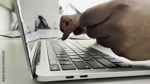 Young man paying online through credit card. Online purchases, close-up of fingers. photo