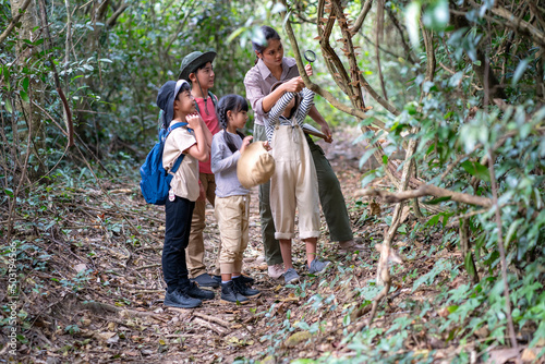 Asian female teachers are taking students on a nature trail to study nature from real places, educational concepts, adventures.