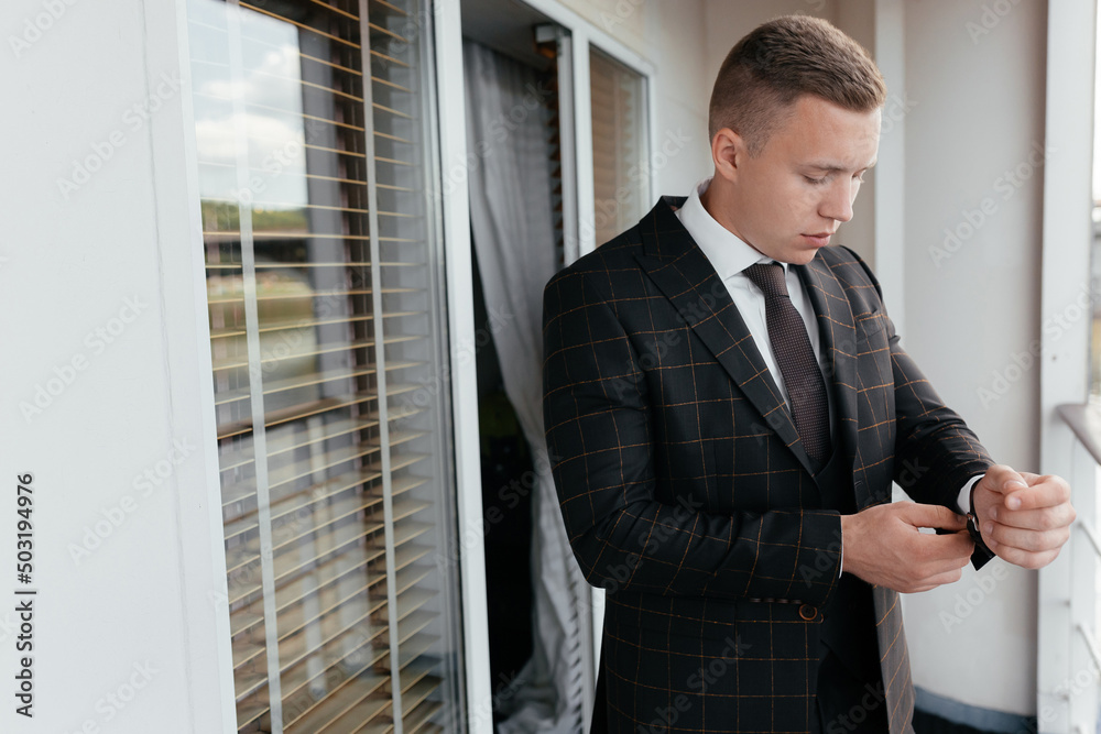 Businessman adjusting jacket on balcony Businessman adjusting jacket on balcony