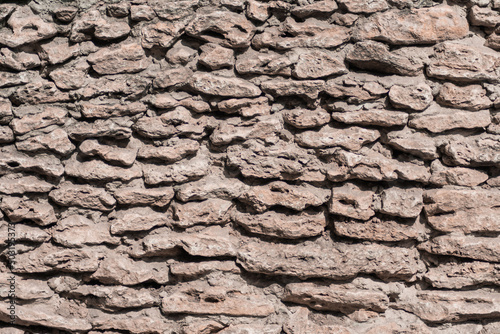 Photo of a fragment of a wall made from rough stone